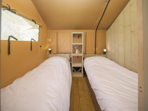 Vue intérieure de la tente safari Ranger Lodge avec deux lits simples au parc Den Blanken, Pays-Bas.