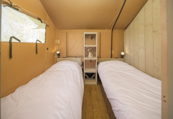 Interieur van de Ranger Lodge safaritent met twee eenpersoonsbedden op Recreatiepark Den Blanken, Nederland.