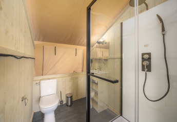 Bagno in una tenda safari Ranger Lodge al Recreation Park Den Blanken, con doccia e servizi igienici.