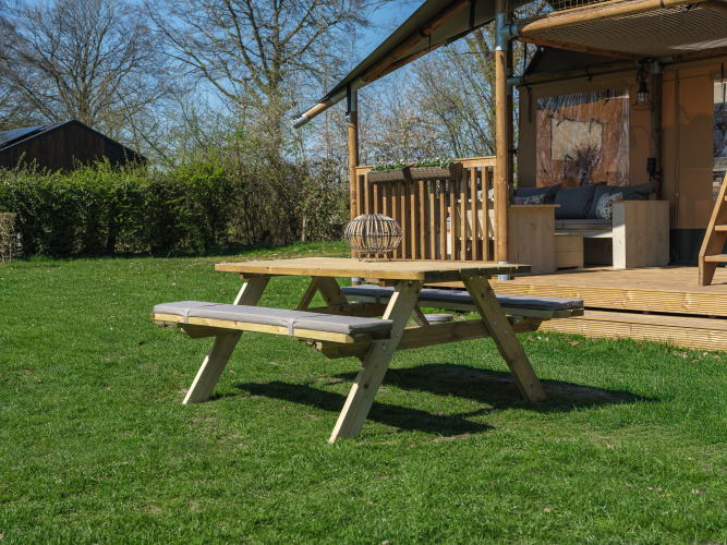 Mesa de picnic al aire libre frente a la tienda safari Ranger Lodge en Recreation Park Den Blanken, Países Bajos.