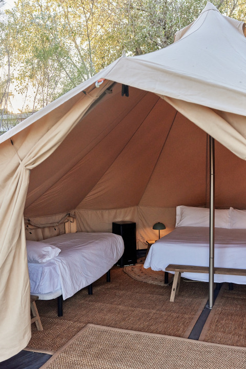 Innenansicht eines geräumigen Glamping-Bell-Zeltes mit zwei Betten und Einrichtung, TAIGA Delta de l'Ebre, Spanien.