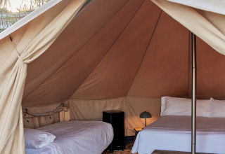 Innenansicht eines geräumigen Glamping-Bell-Zeltes mit zwei Betten und Einrichtung, TAIGA Delta de l'Ebre, Spanien.