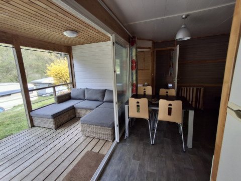 Binnenzicht van Chalet Pauline bij Centre de Vacances Tariche met eetruimte en terras met zithoek.