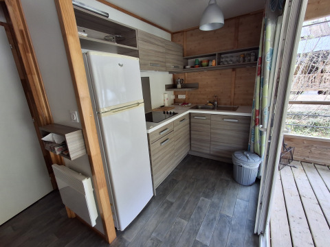 Moderne køkken i Chalet Pauline, Centre de Vacances Tariche, Schweiz, med træfinish og apparater.
