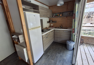 Moderne køkken i Chalet Pauline, Centre de Vacances Tariche, Schweiz, med træfinish og apparater.