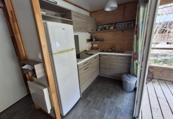 Moderne køkken i Chalet Pauline, Centre de Vacances Tariche, Schweiz, med træfinish og apparater.