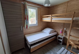 Knusse slaapkamer in Chalet Pauline bij Centre de Vacances Tariche in Zwitserland met stapelbed en kast.
