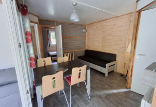 Binnenzicht van Chalet Pauline in Centre de Vacances Tariche, Zwitserland, met eettafel en zetel.