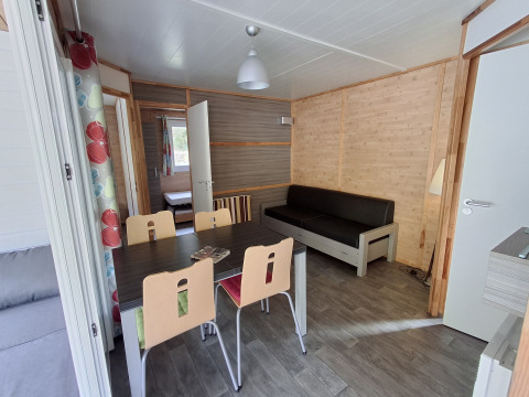 Binnenzicht van Chalet Pauline in Centre de Vacances Tariche, Zwitserland, met eettafel en zetel.