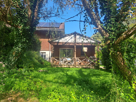 Chalet confort (rivierzicht) bij Centre de Vacances Tariche in Zwitserland, omgeven door weelderig groen.