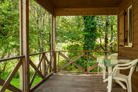 Houten veranda met zicht op rivier en bos bij Chalet confort, Centre de Vacances Tariche, Zwitserland.