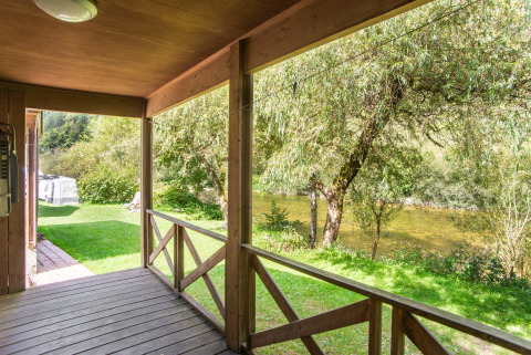 Gezicht vanaf de houten veranda van Chalet confort met uitzicht op de rivier in Centre de Vacances Tariche, Zwitserland.