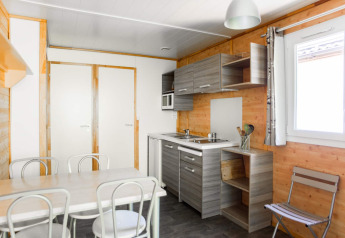 Moderne køkken og spisestue i Chalet confort med udsigt over floden ved Centre de Vacances Tariche, Schweiz.