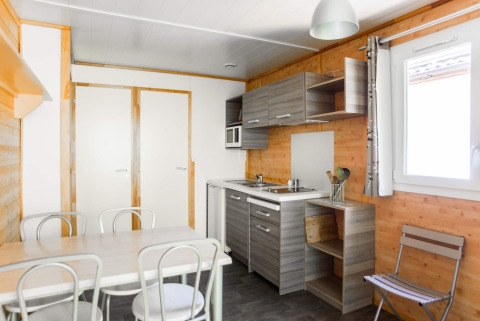 Modern kitchen and dining area in Chalet confort with river view at Centre de Vacances Tariche, Switzerland.