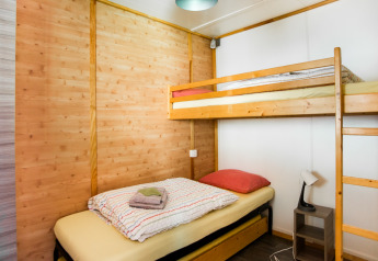 Gezellige kamer met stapelbed en eenpersoonsbed in Chalet confort, Centre de Vacances Tariche, Zwitserland.