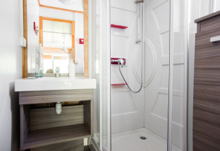 Modernes Chalet-Bad mit Dusche und Spiegel im Centre de Vacances Tariche in der Schweiz.