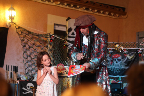 Un mago disfrazado de pirata entretiene a una niña en Flower Camping La Rivière en Provence-Alpes-Côte d’Azur.