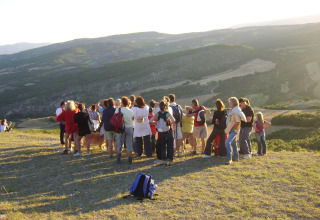 En gruppe mennesker nyder udsigten over de smukke bakker ved Flower Camping La Rivière i Provence, Frankrig.