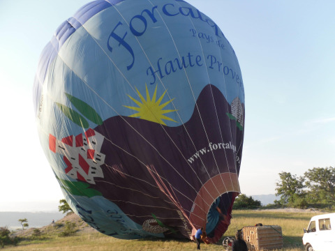 Montgolfière en cours de gonflage sur un champ à Flower Camping La Rivière, Provence-Alpes-Côte d’Azur, France.