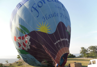 Heißluftballon wird auf einer Wiese bei Flower Camping La Rivière in der Provence-Alpes-Côte d’Azur vorbereitet.