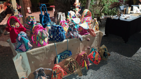 Bunte handgefertigte Taschen auf einem Marktstand bei Flower Camping La Rivière in Provence, Frankreich.