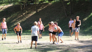Niños y adolescentes juegan un partido de pelota al aire libre en Flower Camping La Rivière en el sur de Francia.