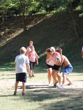 Niños y adolescentes juegan un partido de pelota al aire libre en Flower Camping La Rivière en el sur de Francia.