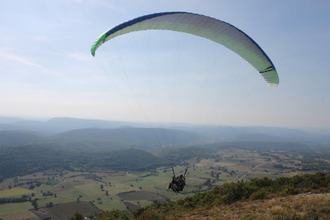 Parapente au-dessus de Flower Camping La Rivière dans le paysage de Provence-Alpes-Côte d’Azur, France.