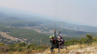 Dos personas haciendo parapente tándem desde una colina, cerca de Flower Camping La Rivière en Francia.