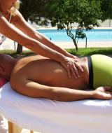 Huésped recibe un masaje relajante al aire libre junto a la piscina en Flower Camping La Rivière en Provenza, Francia.