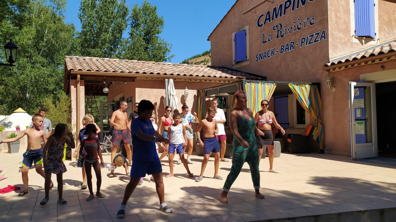 Kids and adults join an outdoor dance activity at Flower Camping La Rivière in Provence-Alpes-Côte d’Azur, France.