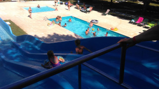 Area piscina adatta alle famiglie con scivolo d'acqua a Camping Le Périgord, parco vacanze in Nouvelle-Aquitaine, Francia.