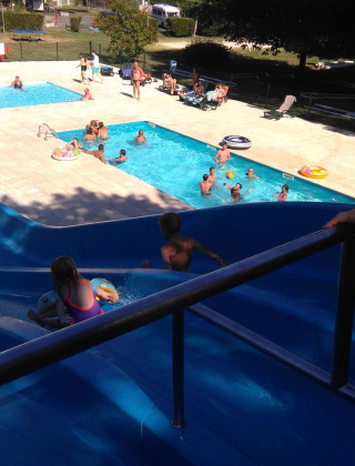 Zona de piscina familiar con tobogán acuático en Camping Le Périgord, un parque de vacaciones en Nouvelle-Aquitaine, Francia.