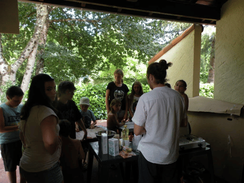 Gruppo di persone riunite su un patio coperto al Camping Le Périgord, villaggio vacanze in Nouvelle-Aquitaine.