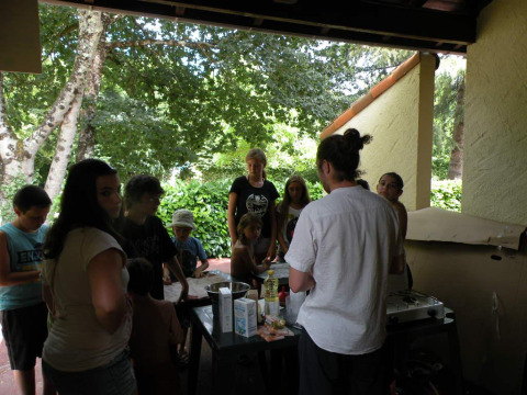 Grupo de personas reunidas bajo un porche en Camping Le Périgord, parque vacacional en Nouvelle-Aquitaine.
