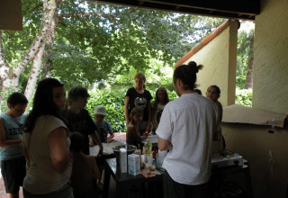 Gruppo di persone riunite su un patio coperto al Camping Le Périgord, villaggio vacanze in Nouvelle-Aquitaine.