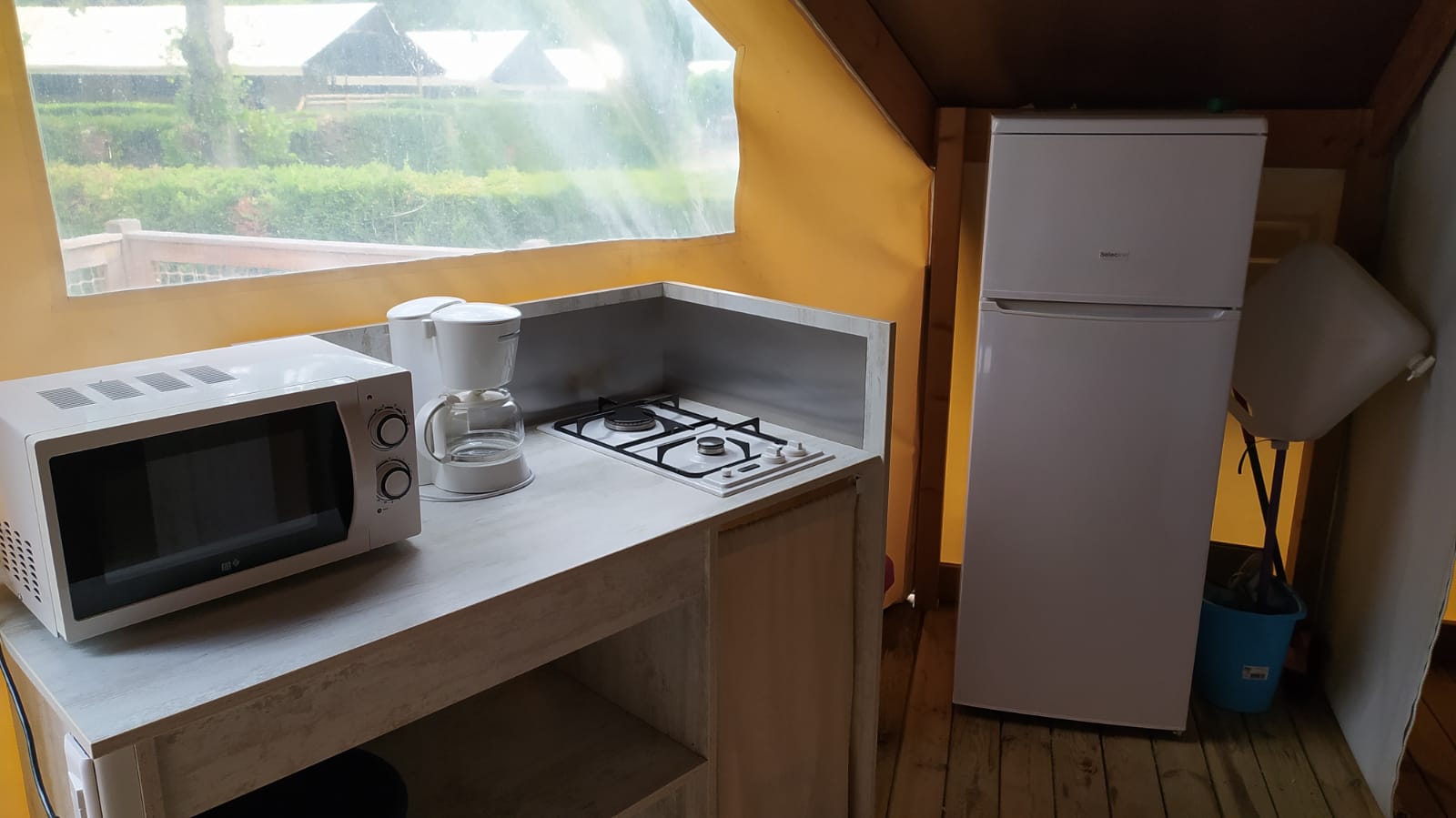 Keukenhoek in de Ecolodge toilé Standard bij Flower Camping La Rivière in Frankrijk met apparatuur.