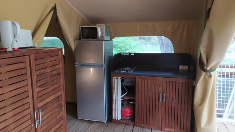 Binnenzicht van een compacte keuken in Lodge op palen Confort op Flower Camping La Rivière, Frankrijk.