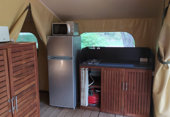 Indvendig visning af et lille køkken i en Lodge op palen Confort på Flower Camping La Rivière, Frankrig.