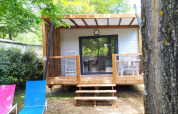 Chalet Cajou Confort en Flower Camping La Rivière en Francia, rodeado de árboles y naturaleza.