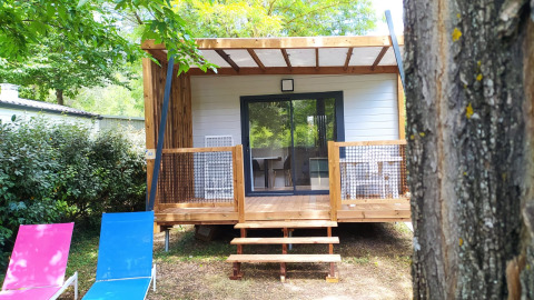 Chalet Cajou Confort en Flower Camping La Rivière en Francia, rodeado de árboles y naturaleza.