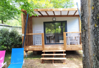 Chalet Cajou Confort en Flower Camping La Rivière en Francia, rodeado de árboles y naturaleza.