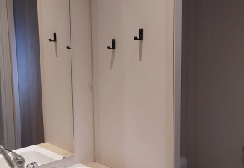 Moderne badkamer in Chalet Cajou Confort met wastafel, spiegel, handdoeken en toilet bij Flower Camping La Rivière.