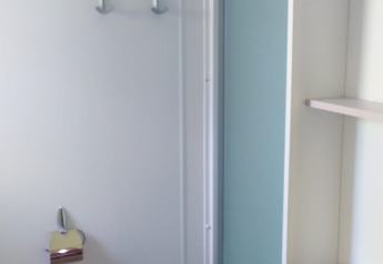 Bagno moderno in un alloggio glamping con doccia, WC e arredo semplice dai colori chiari.