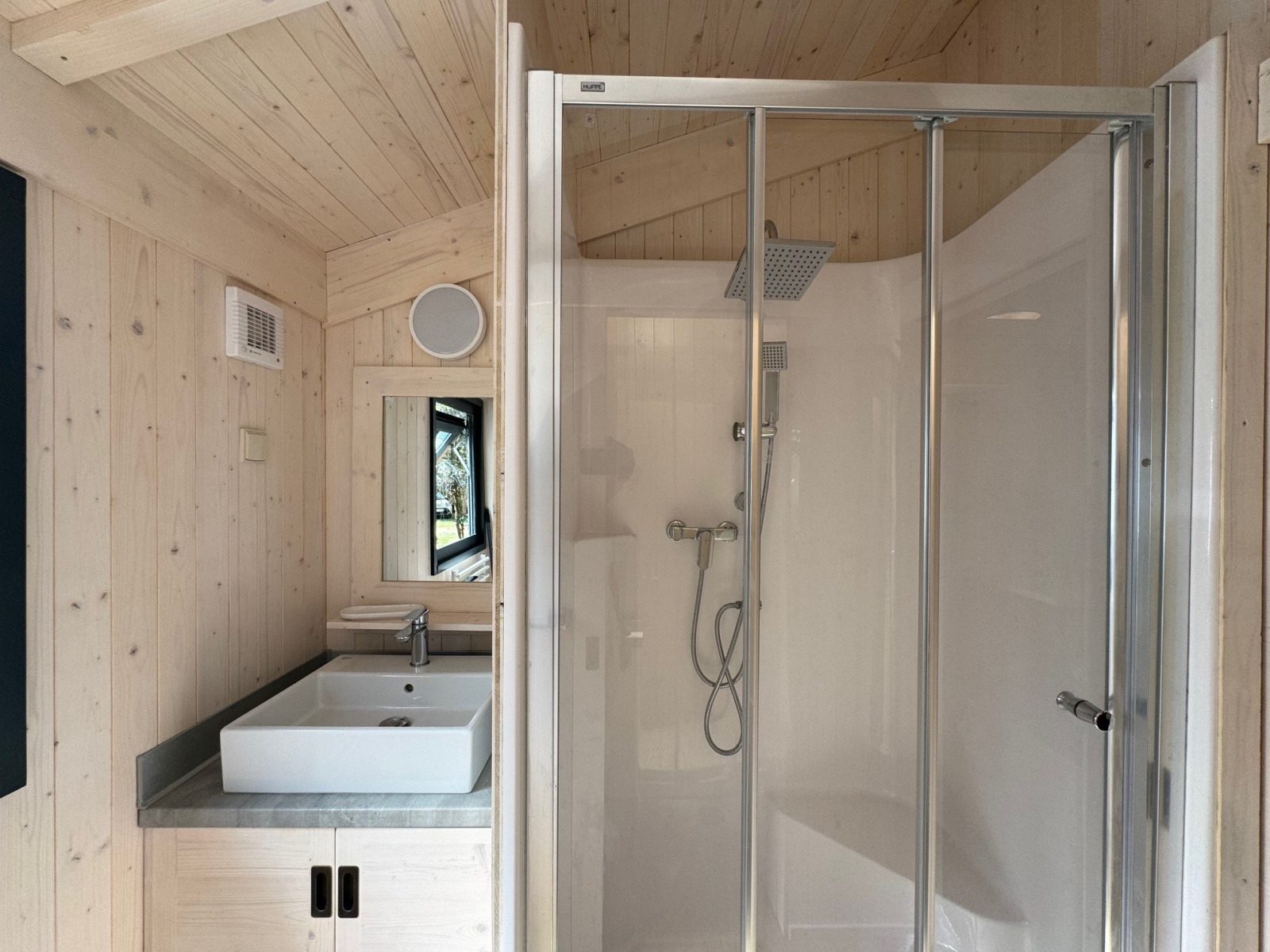 Badkamer in Charme hut met jacuzzi op Camping Le Périgord, Frankrijk, met douche en wastafel.