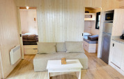 Vista interna della Premium Hut al Camping Le Périgord in Francia, con pareti in legno e arredi accoglienti.