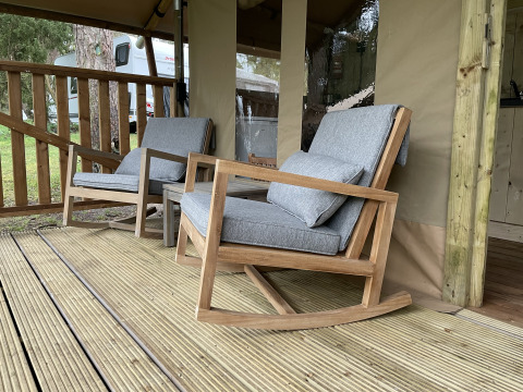 Twee gezellige schommelstoelen met grijze kussens op het terras van de safaritent Summer Lodge in Beerze Bulten.