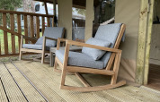 Twee gezellige schommelstoelen met grijze kussens op het terras van de safaritent Summer Lodge in Beerze Bulten.