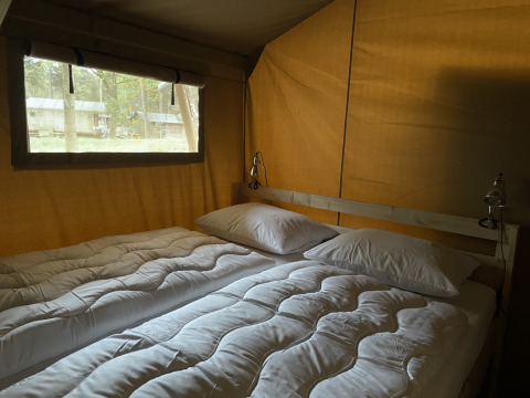 Binnenzicht van safaritent met tweepersoonsbed bij Summer Lodge, Beerze Bulten, Nederland.