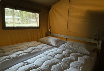 Binnenzicht van safaritent met tweepersoonsbed bij Summer Lodge, Beerze Bulten, Nederland.